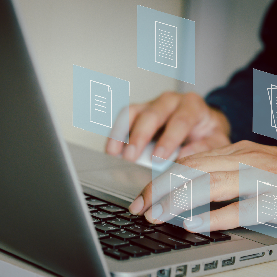 Image of hands typing on laptop with graphics of pieces of paper flying out