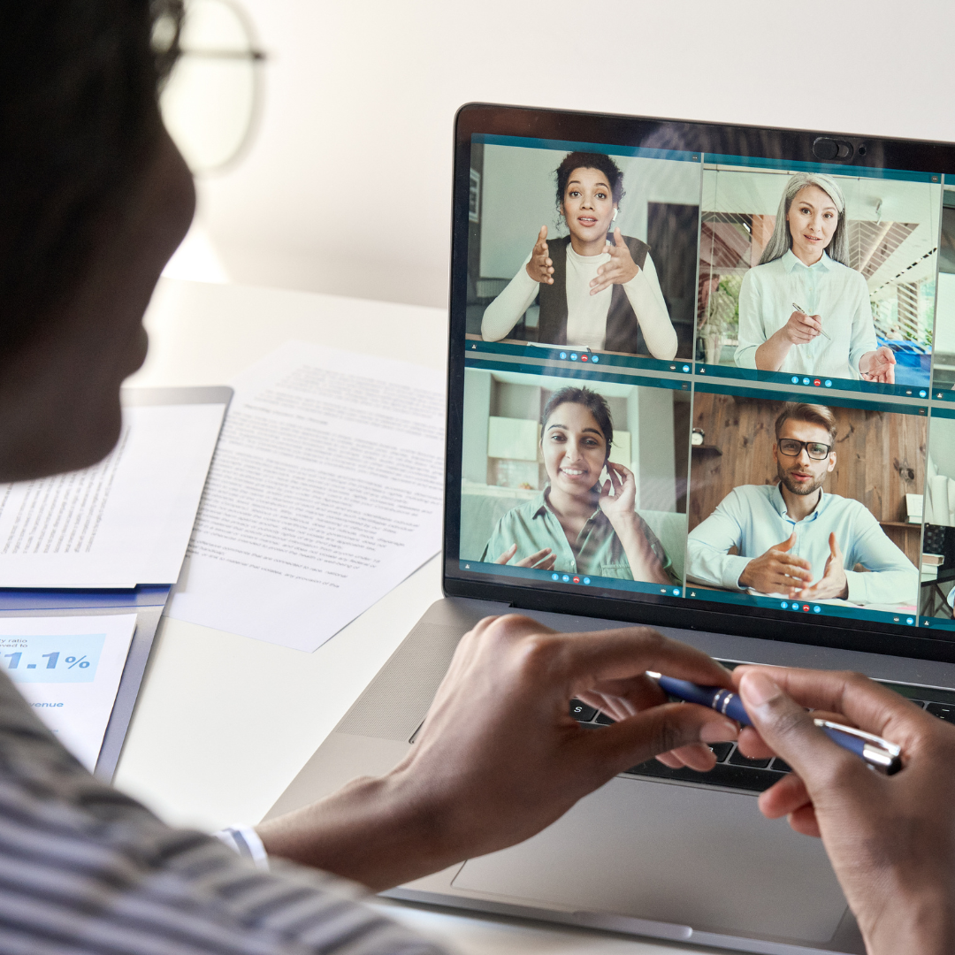 Photo of a person looking at a laptop with a virtual meeting